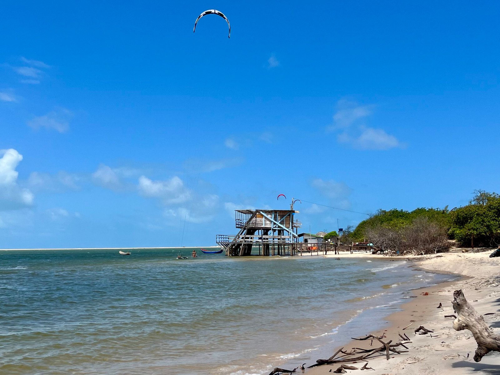 kites sur une plage de sable blanc avec pilotis